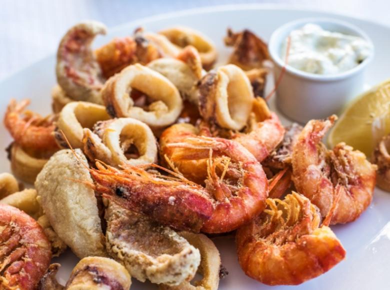 Fritto misto di calamari e gamberi con salsa e limone.